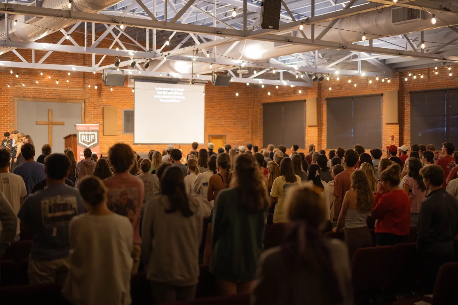 A full room of students listening together during Large Group