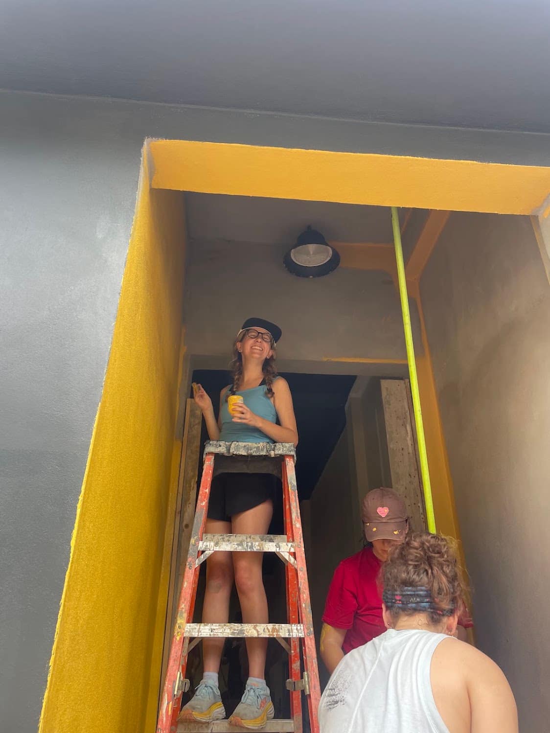 A student working from a ladder inside the project site